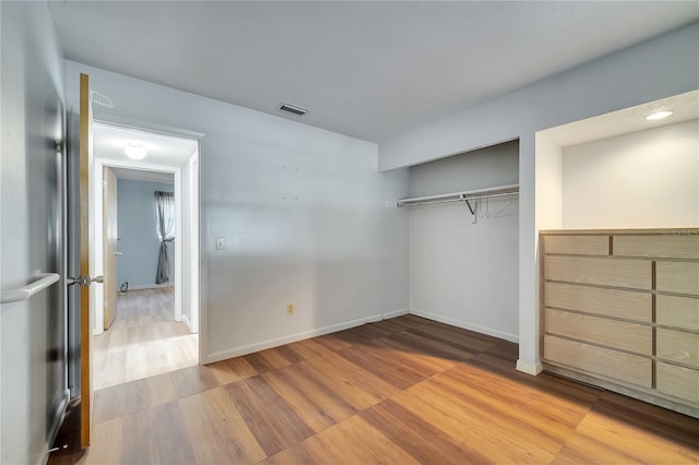 unfurnished bedroom featuring hardwood / wood-style floors and a closet