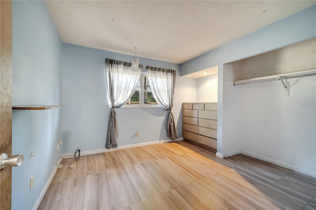 unfurnished bedroom featuring light hardwood / wood-style flooring and a textured ceiling