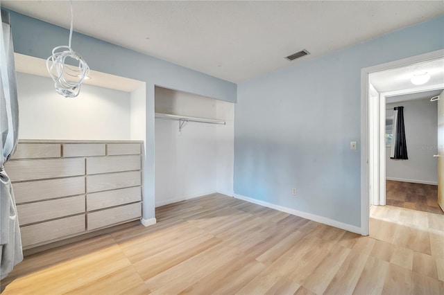 unfurnished bedroom with light hardwood / wood-style floors and a closet