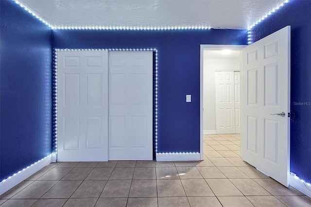 unfurnished bedroom with tile patterned flooring and a closet