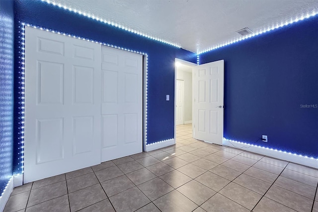 unfurnished bedroom featuring tile patterned flooring and a textured ceiling