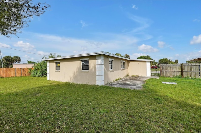 rear view of property with a lawn and a patio area