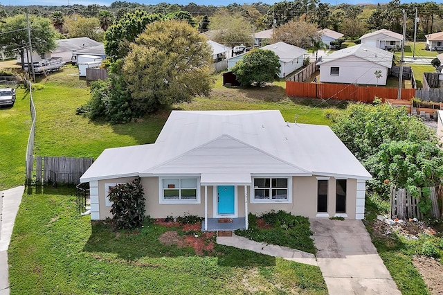 view of front of property with stucco siding, fence, and a front yard