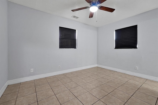 empty room with ceiling fan, visible vents, and baseboards