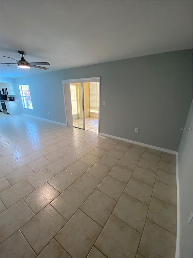 spare room with ceiling fan and light tile patterned floors