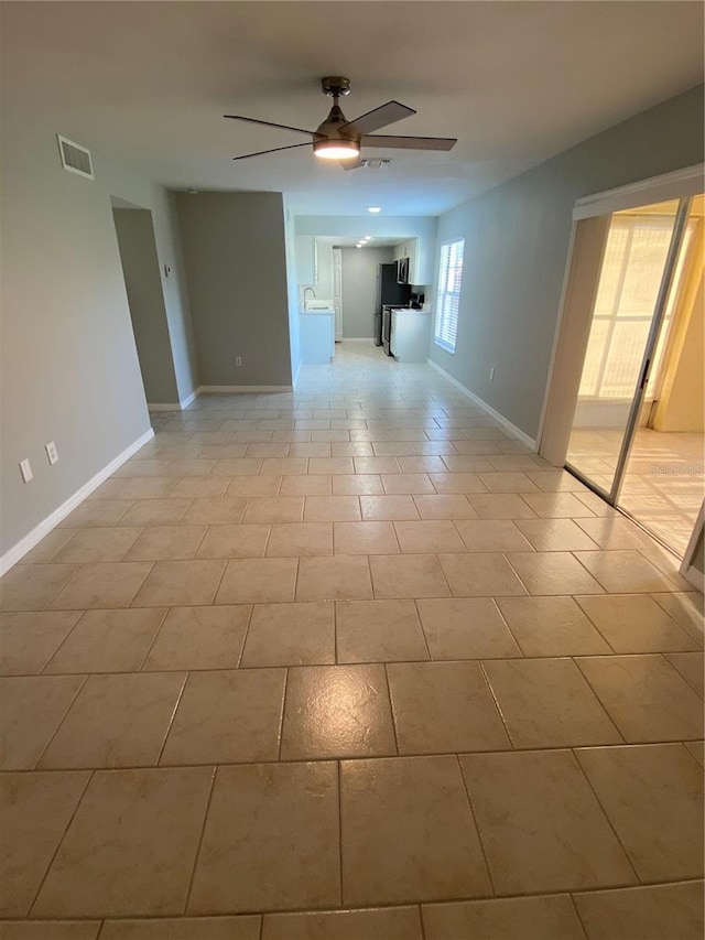 tiled spare room with ceiling fan