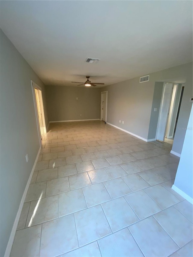 tiled spare room featuring ceiling fan