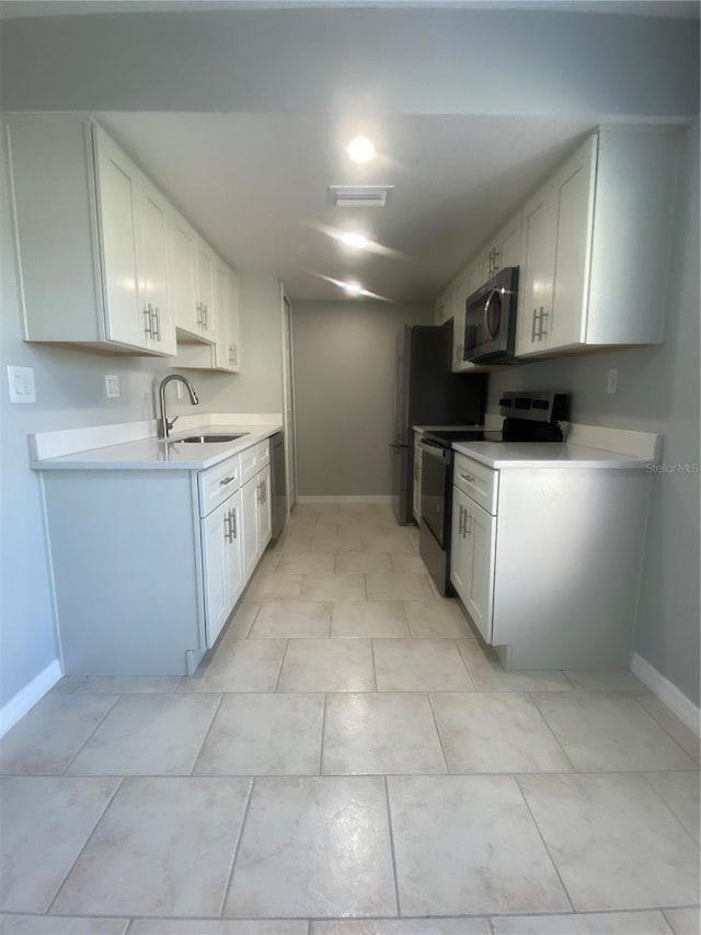 kitchen with white cabinetry, stainless steel appliances, and sink