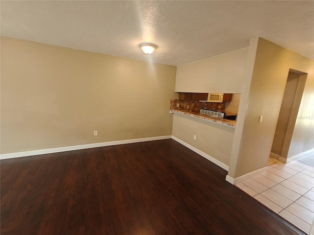 unfurnished living room featuring light hardwood / wood-style floors and a textured ceiling