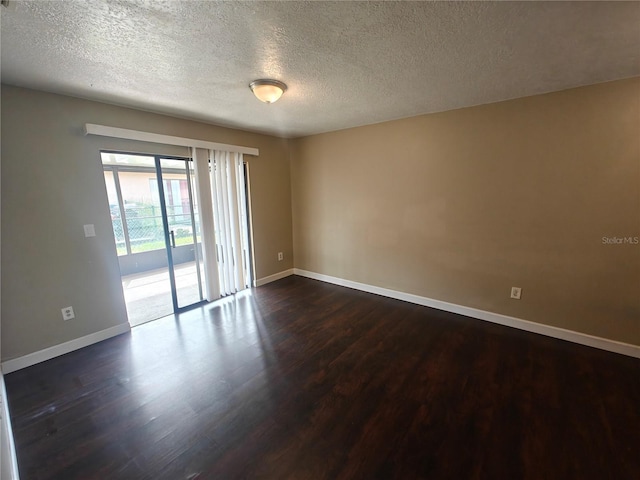 spare room with dark wood-type flooring and a textured ceiling