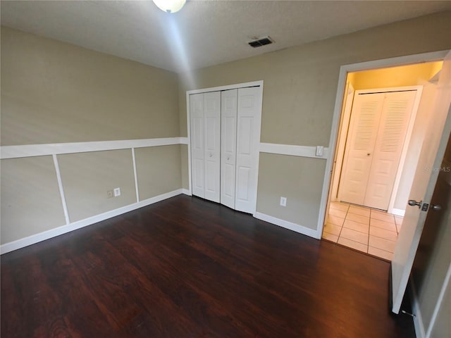 unfurnished bedroom featuring dark hardwood / wood-style floors and a closet