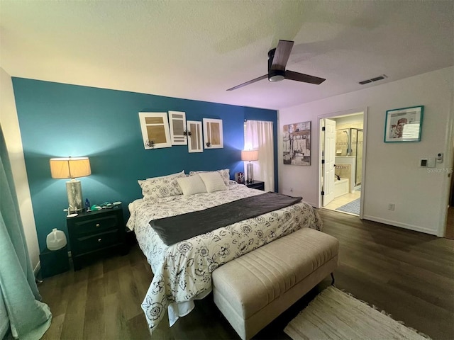 bedroom with dark wood-type flooring, ceiling fan, and connected bathroom