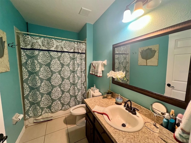 bathroom with tile patterned flooring, vanity, toilet, and walk in shower