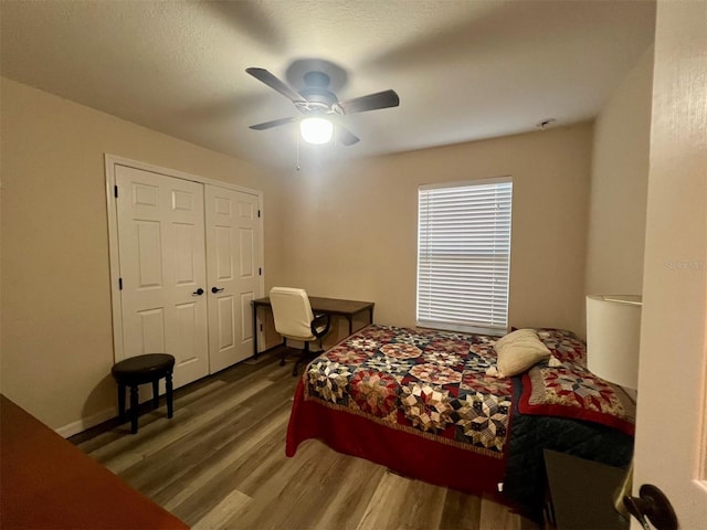 bedroom featuring wood-type flooring, ceiling fan, and a closet