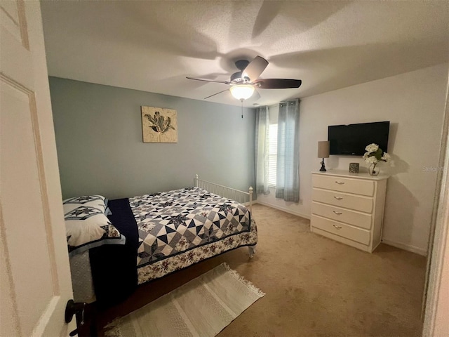 bedroom with ceiling fan and light carpet