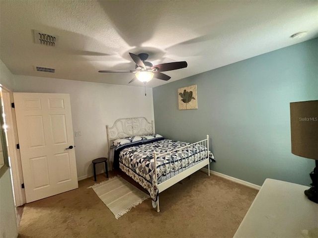 carpeted bedroom featuring a textured ceiling and ceiling fan