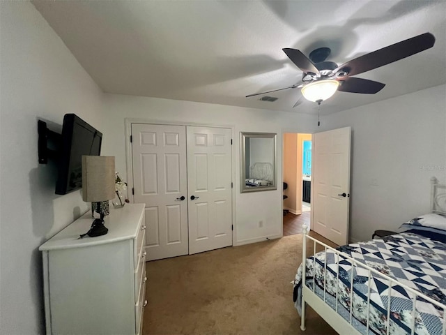 carpeted bedroom featuring a closet and ceiling fan