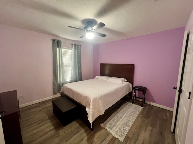 bedroom featuring ceiling fan, dark hardwood / wood-style floors, and a textured ceiling