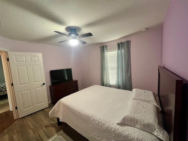 bedroom with wood-type flooring, ceiling fan, and a textured ceiling