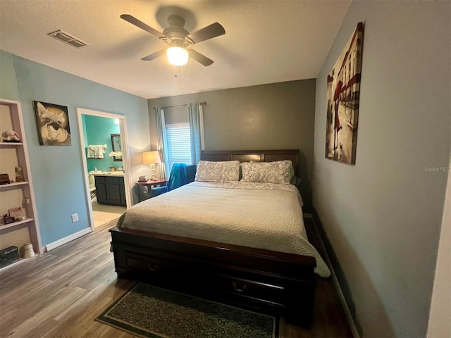 bedroom featuring connected bathroom, ceiling fan, and light wood-type flooring