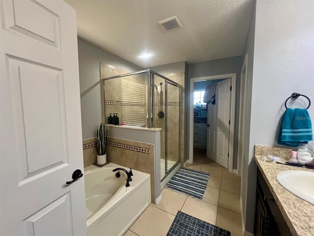 bathroom with vanity, independent shower and bath, tile patterned flooring, and a textured ceiling