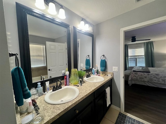 bathroom with tile patterned flooring, vanity, ceiling fan, and a textured ceiling