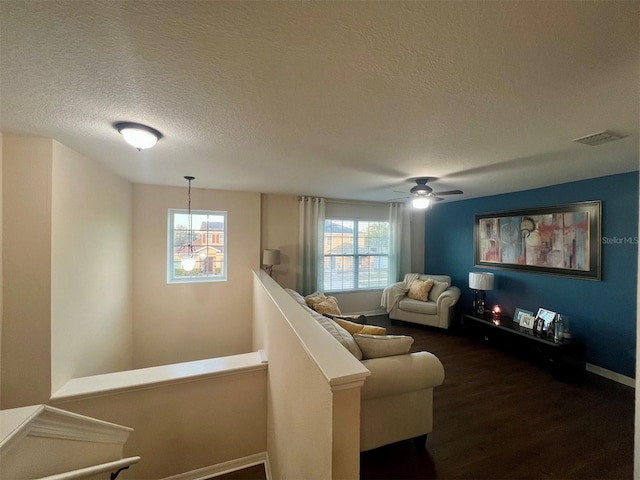 living room with dark hardwood / wood-style floors, a chandelier, and a textured ceiling