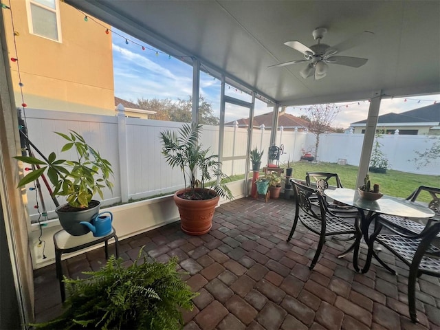 sunroom / solarium featuring ceiling fan