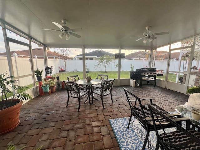 sunroom featuring a water view and ceiling fan