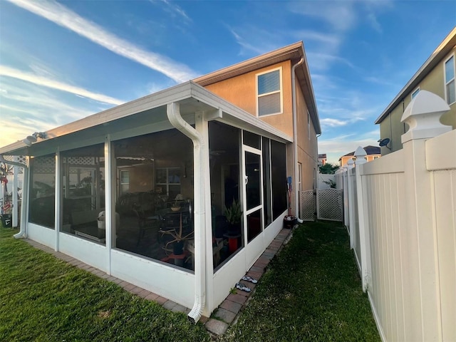 view of property exterior featuring a yard and a sunroom