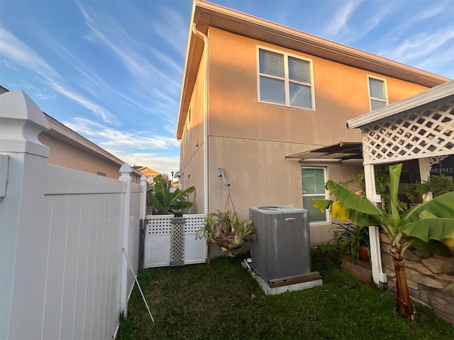 view of home's exterior with central AC and a yard