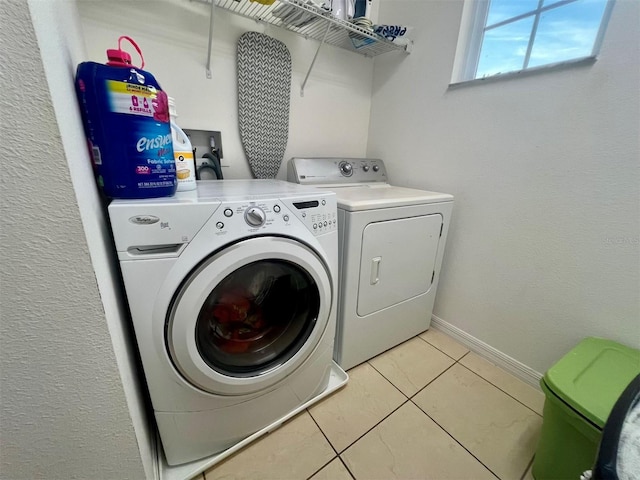 laundry room with washer and dryer and light tile patterned floors