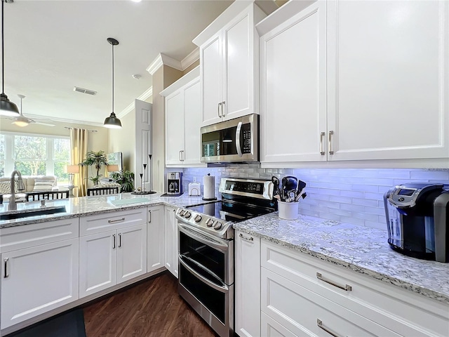 kitchen featuring appliances with stainless steel finishes, decorative light fixtures, white cabinetry, sink, and ornamental molding