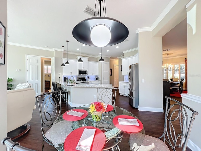 dining room featuring dark wood-type flooring, crown molding, and a chandelier