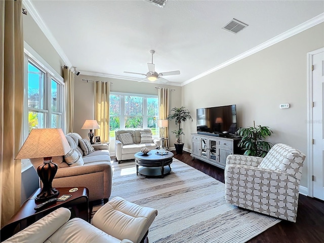 living room with dark hardwood / wood-style flooring, crown molding, and ceiling fan