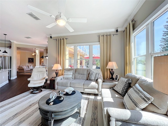 living room featuring crown molding, plenty of natural light, and ceiling fan