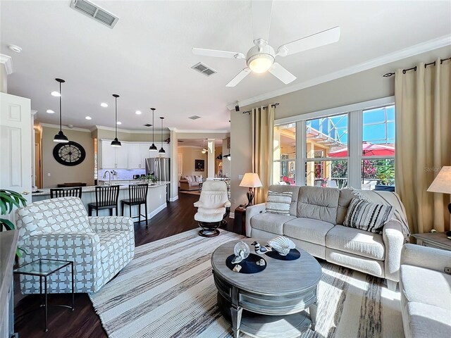 living room featuring crown molding, ceiling fan, and dark hardwood / wood-style flooring