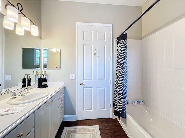 bathroom with wood-type flooring, shower / bath combo with shower curtain, and vanity