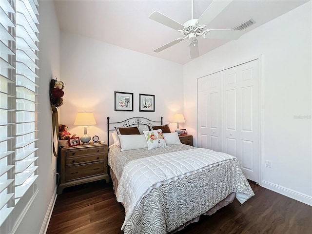 bedroom featuring multiple windows, dark wood-type flooring, ceiling fan, and a closet