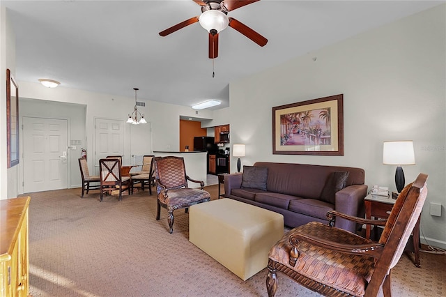 living room with ceiling fan with notable chandelier and light carpet