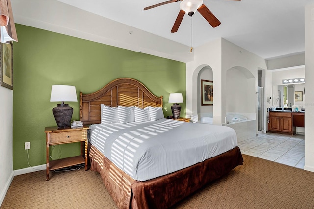 tiled bedroom with ceiling fan and ensuite bath