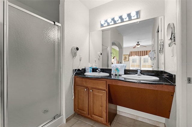 bathroom with walk in shower, ceiling fan, vanity, and tile patterned flooring