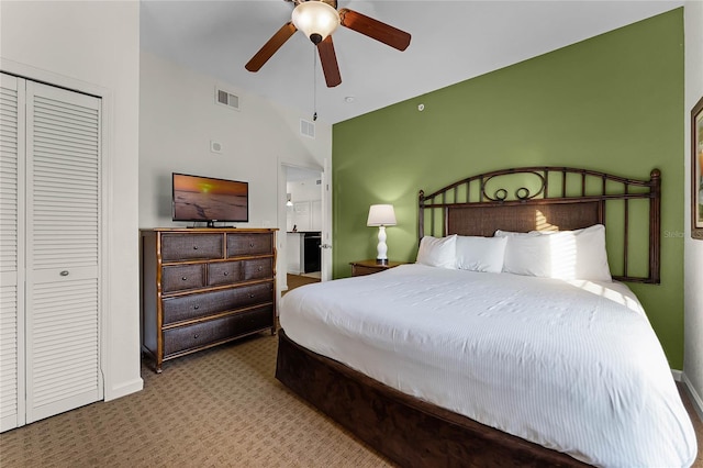 bedroom with ceiling fan, lofted ceiling, carpet flooring, and a closet