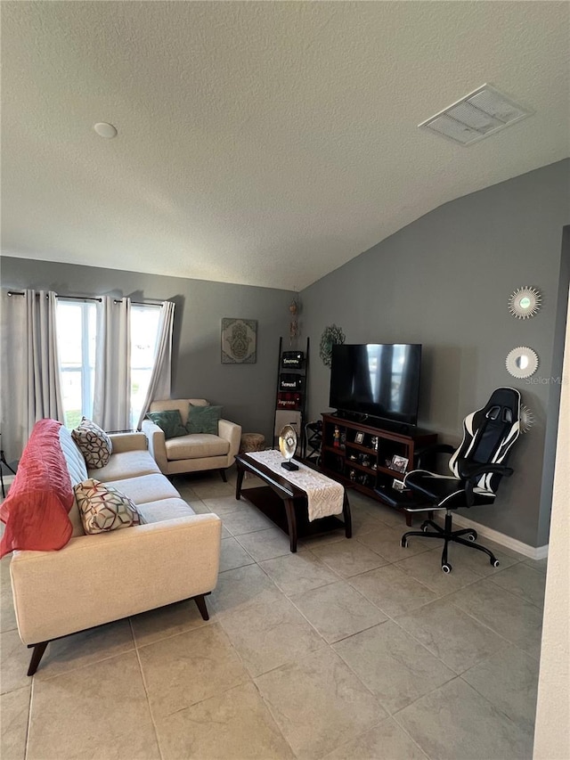 tiled living room featuring vaulted ceiling and a textured ceiling