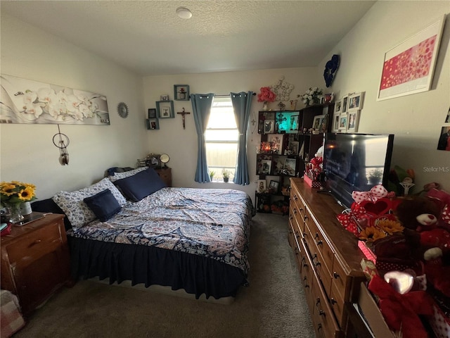 bedroom featuring dark carpet and a textured ceiling