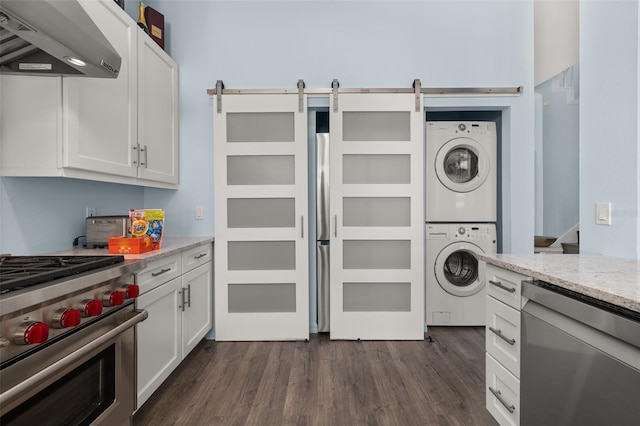 laundry area with dark hardwood / wood-style floors and stacked washing maching and dryer