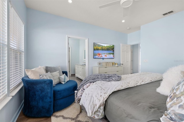 bedroom with ceiling fan, ensuite bath, and wood-type flooring