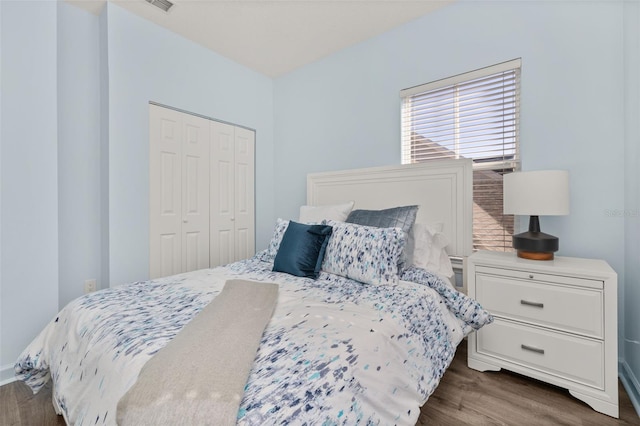 bedroom with dark wood-type flooring and a closet