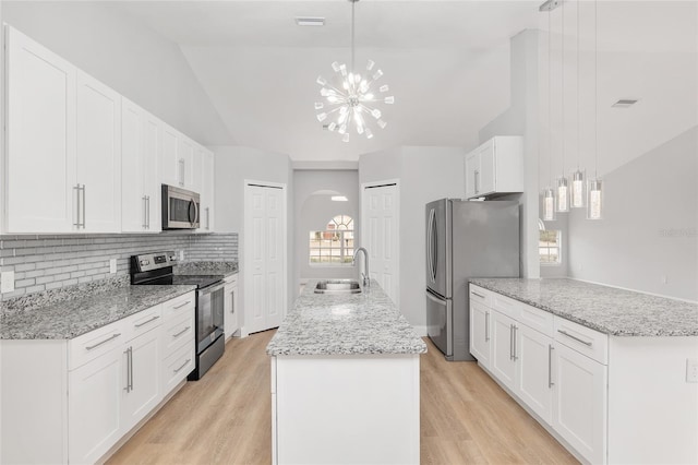 kitchen featuring white cabinetry, appliances with stainless steel finishes, decorative light fixtures, and sink