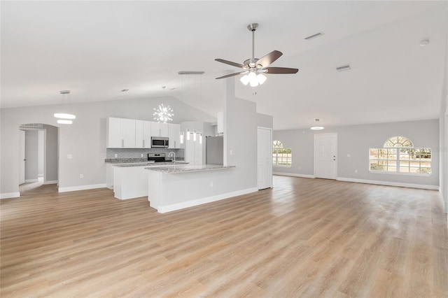 unfurnished living room featuring plenty of natural light, high vaulted ceiling, ceiling fan, and light wood-type flooring